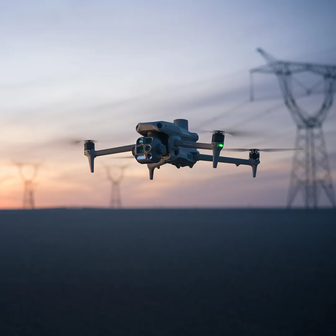 DJI Matrice 4T in flight at dusk near power infrastructure